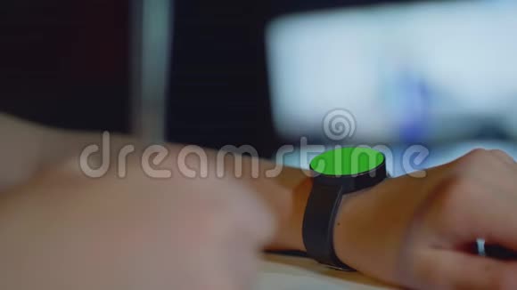 在女孩的左手上用绿色的圆形屏幕聚焦手表在女孩的右手上用离焦的钢笔视频的预览图