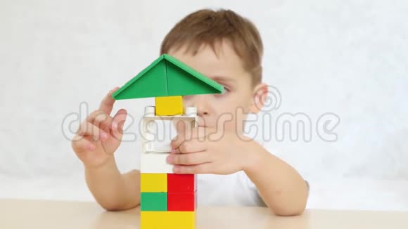 一个孩子正坐在一张白色背景的桌子上用彩色积木玩耍孩子和玩具重点是玩具视频的预览图