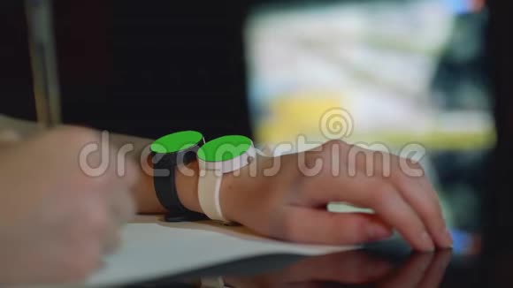 在女孩的左手上用绿色屏幕聚焦两只黑白手表视频的预览图