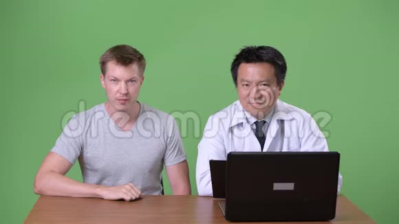 成熟的日本男性医生和年轻病人讨论视频的预览图
