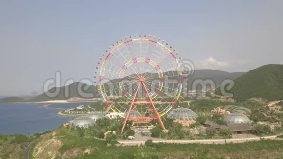 色彩缤纷的摩天轮在游乐园中海山景观鸟瞰大型摩天轮游乐园视频的预览图