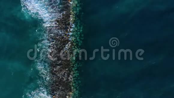靠近海岸的大西洋表面的俯视图波浪在防波堤上滚动岛屿海岸视频的预览图