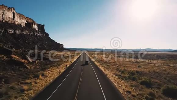 无人机跟随汽车行驶在公路道路之间的史诗般陡峭的峡谷山脉和惊人的沙漠天际线在美国视频的预览图