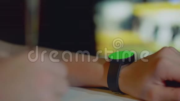 在女孩的左手上用绿色的圆形屏幕聚焦手表在女孩的右手上用离焦的钢笔视频的预览图