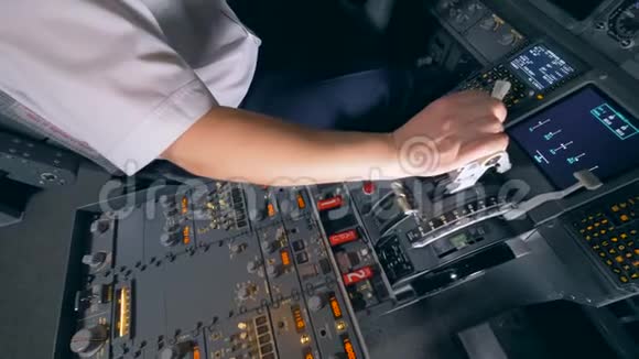 一名飞行员在飞行模拟器中的飞机杠杆上握住他的手4K视频的预览图