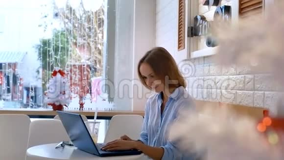 女孩在笔记本电脑与窗口与加兰视频的预览图
