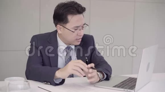 慢动作商人在办公室的办公桌上心烦意乱亚洲商人因工作而沮丧视频的预览图