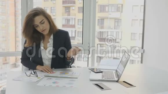 办公室工作人员一个戴眼镜的女商人坐在办公楼办公室的扶手椅上准备文件视频的预览图