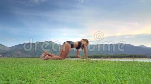 Flycam秀女孩坐在瑜伽姿势与丘陵景观视频的预览图