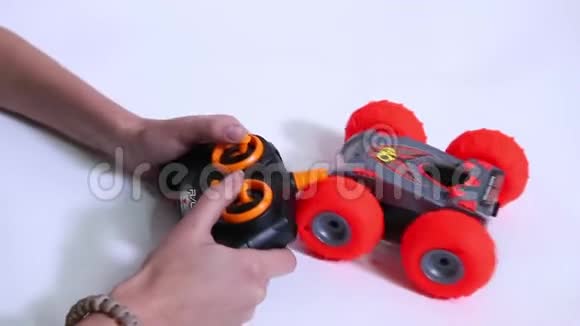 女子操作无线电控制红色玩具跑车视频的预览图