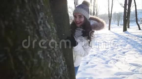 快乐的女孩走在冬天的森林里背光快乐年轻的女人调情看着镜头阳光阳光视频的预览图