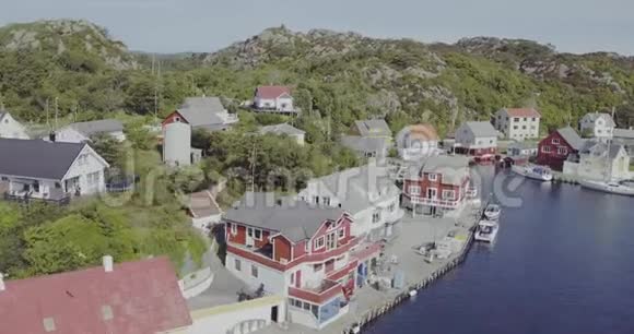 在峡湾海滨的房子和蓝水上近距离飞行视频的预览图