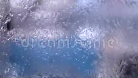 玻璃上的水下雨了水的质地窗户上的雨滴视频的预览图