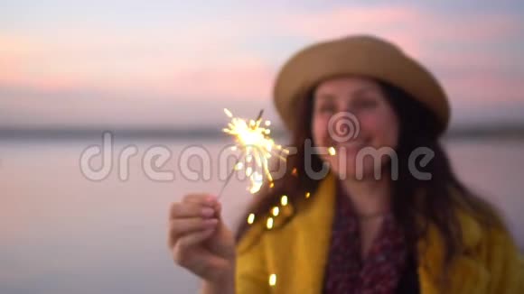 特写一幅漂亮的女孩的肖像手里拿着火花火花向不同方向散射视频的预览图
