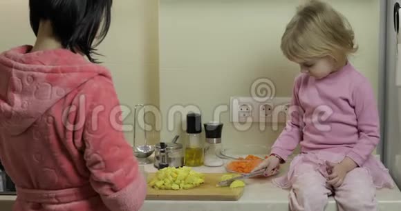 可爱的小女孩和她妈妈一起做饭小女儿和妈妈在一起视频的预览图