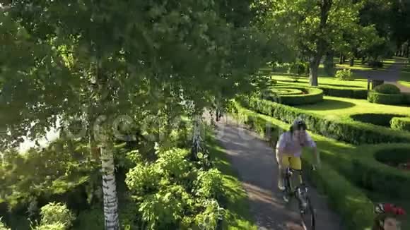 四个快乐的学生在公园里骑自行车视频的预览图