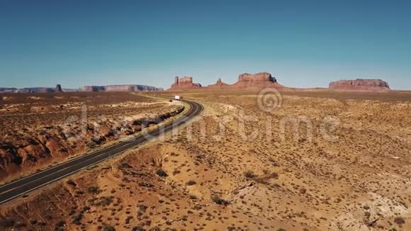 在美国纪念碑山谷红色货运卡车沿着沙漠公路行驶具有惊人的山脉天际线视频的预览图