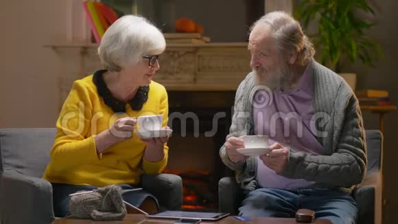 老年妇女和退休老人在舒适的酒店房间喝茶视频的预览图