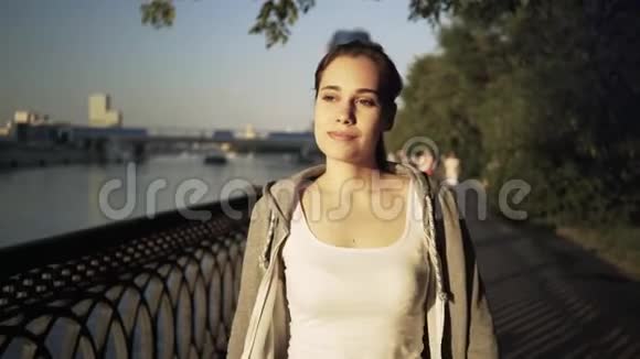 微笑着穿着运动服的年轻女子在莫斯科市街散步视频的预览图