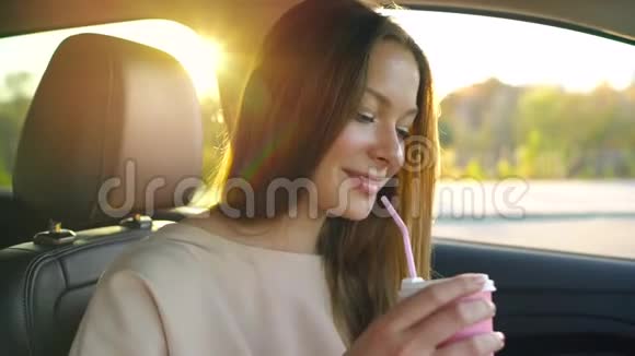 女人在智能手机上说话在车里喝咖啡视频的预览图