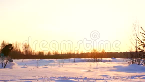 冬日夕阳下人的轮廓穿过深深的积雪视频的预览图