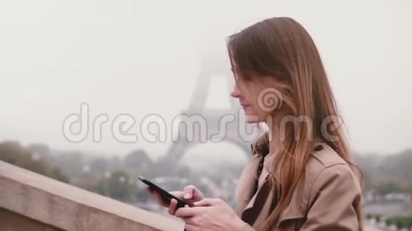 年轻女子在社交网络上聊天使用智能手机站在巴黎埃菲尔铁塔附近法国慢动作视频的预览图
