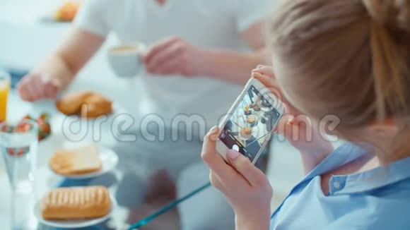 年轻女子为社交媒体拍摄早餐照片视频的预览图
