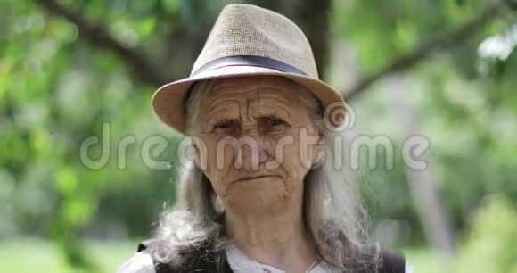 户外草帽里长着灰色长发的老妇人的肖像视频的预览图
