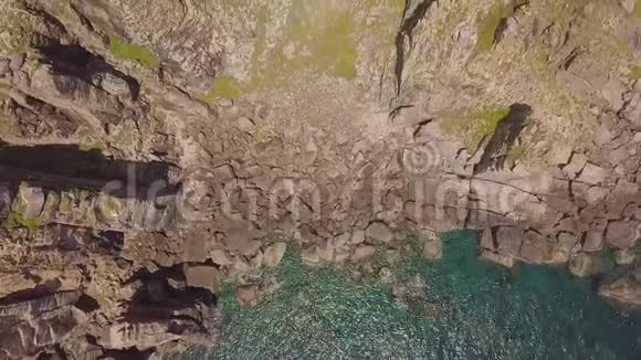 无人机观岩石悬崖和蓝色海水青山悬崖上的空中景观灯塔和海上航行的船只视频的预览图
