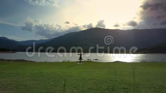 空中观景远方女孩在平静的湖面上做瑜伽视频的预览图
