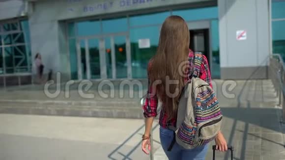 年轻男子步行到现代机场候机楼为她的航班从后面看女性旅行者视频的预览图
