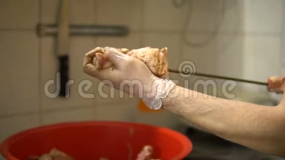 烤架上的烧烤手把生肉放在肉串上视频的预览图