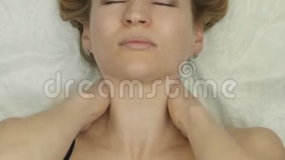 颈部按摩躺在床上金发女性在家做自我按摩抗衰老面部按摩视频的预览图