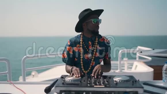 年轻DJ在船上的夏季派对上混合和旋转迪拜夏季海上DJ视频的预览图