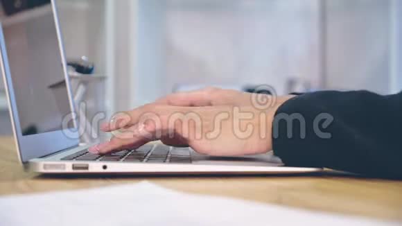 在办公室背景下的笔记本电脑上工作的人手视频的预览图