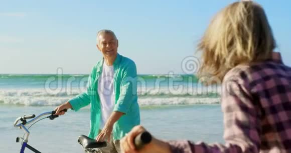 活跃的高加索族夫妇在海滩上骑自行车视频的预览图