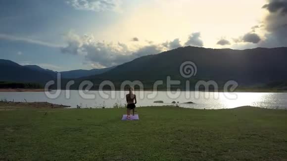 练习者绕着女孩旋转持瑜伽姿势对抗山丘视频的预览图