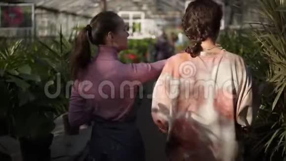 回顾年轻的女性花店与客户一起散步展示她不同的植物解释信息青年视频的预览图