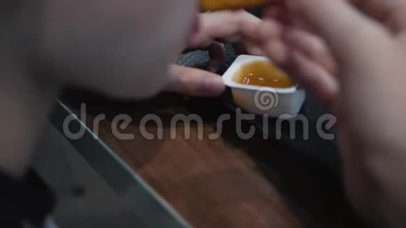 这个男孩正在咖啡馆里吃快餐一个孩子吃带有酱汁和番茄酱的金块视频的预览图