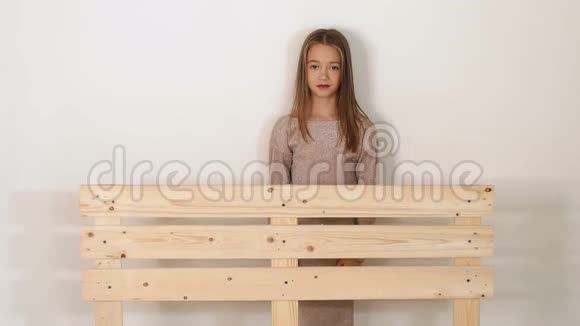 一个小可爱的女孩在工作室靠近一个木制的生态台视频的预览图