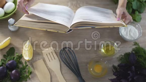女人的手拿着烹饪书女孩选择食谱和翻页视频的预览图