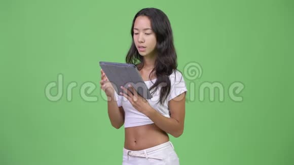 年轻美丽的多民族女性在使用数字平板电脑时思考视频的预览图