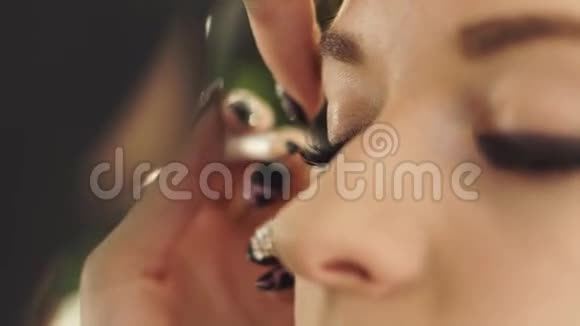 女性化妆师使用黑色眼线为化妆眼睛时尚模特用眼线笔把面罩合上视频的预览图