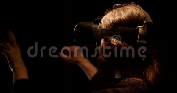 黑暗中的胡子男在虚拟现实眼镜中工作视频的预览图