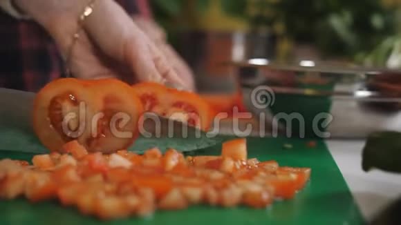 两个女孩在厨房切西红柿做蔬菜沙拉健康的饮食视频的预览图