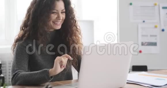 女商人在办公室庆祝网上成功视频的预览图