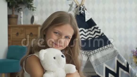 可爱的女孩正抱着一只玩具熊看着相机微笑着视频的预览图
