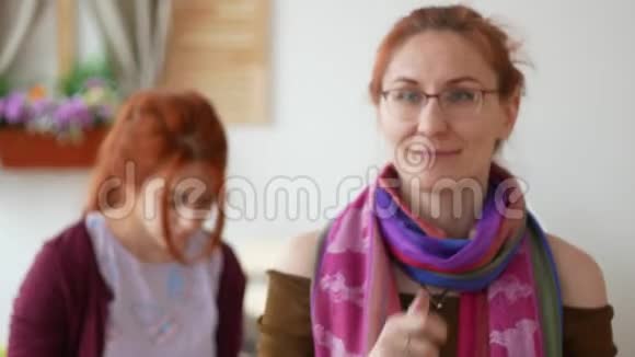 两个白种人年轻女子在客厅里微笑视频的预览图