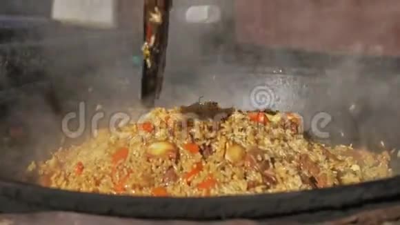 在户外的金属锅中烹制国家亚洲米菜在火上做饭火上的鱼汤大锅里的食物视频的预览图