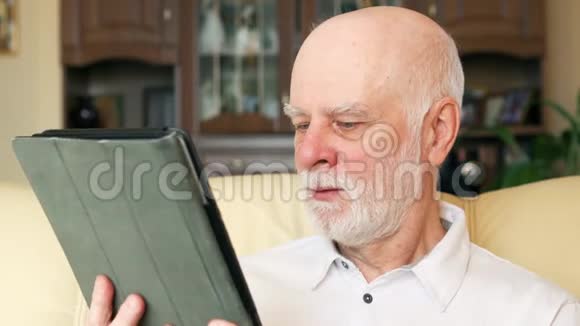 现代老人在家使用平板电脑浏览阅读新闻退休后积极的现代生活视频的预览图